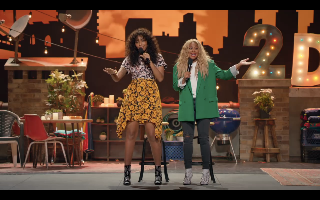 Jessica Williams in two tone floral and Phoebe Robinson in green oversize suit jacket and jeans hosting 2 Dope Queens comedy specials on HBO 2018