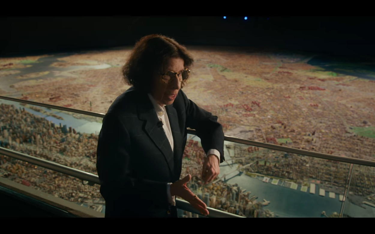 Fran Lebowitz gesticulates from the second floor view overlooking the miniature replica of New York City at the Queens Museum in Netflix' 2021 limited series "Pretend It's a City" directed by Martin Scorsese