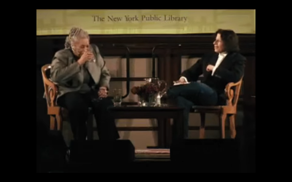 On stage at the New York Public Library in 2008.  Toni Morrison takes a sip of water while Fran Lebowitz speaks.  Interview excerpt appears in Netflix's 2021 series "Pretend It's a City"
